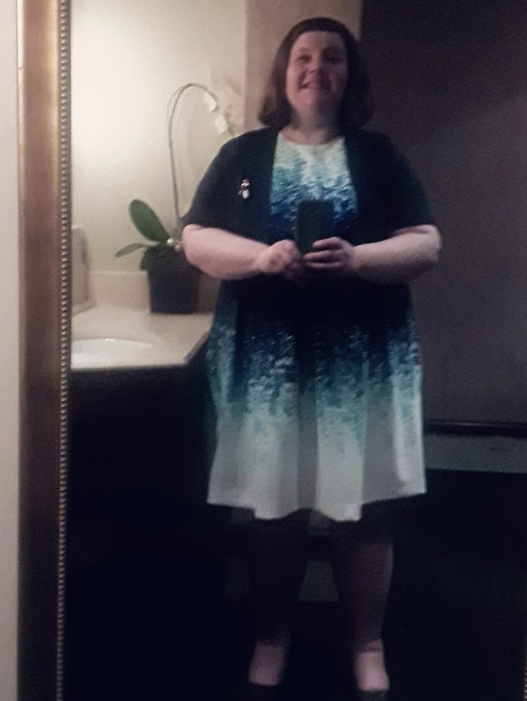 Woman in blue dress taking bathroom selfie